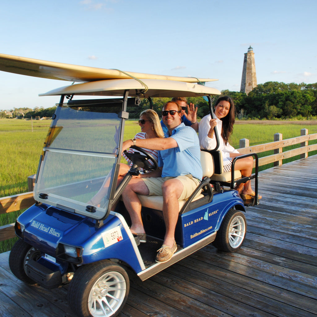 A family loading a Bald Head Blues golf cart on the island